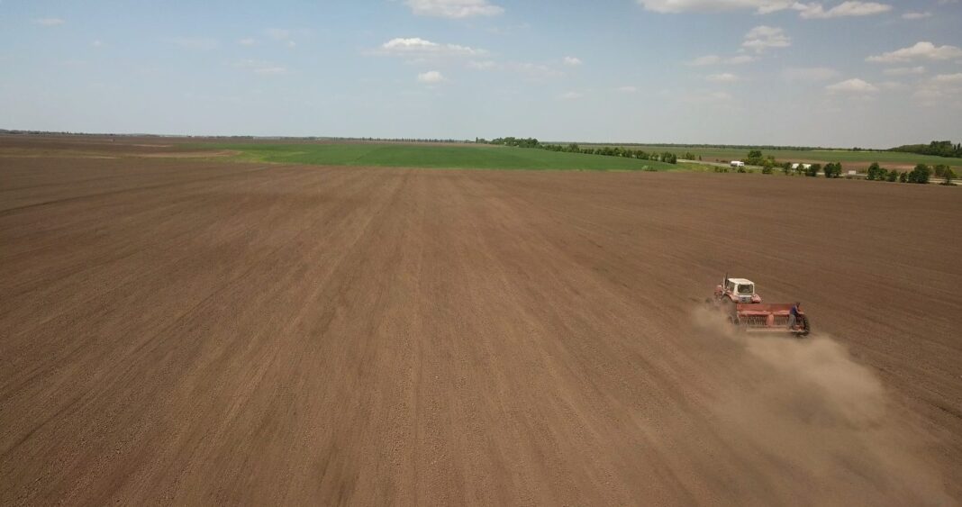 Ciągnik z agregatem uprawowym na zaoranym polu